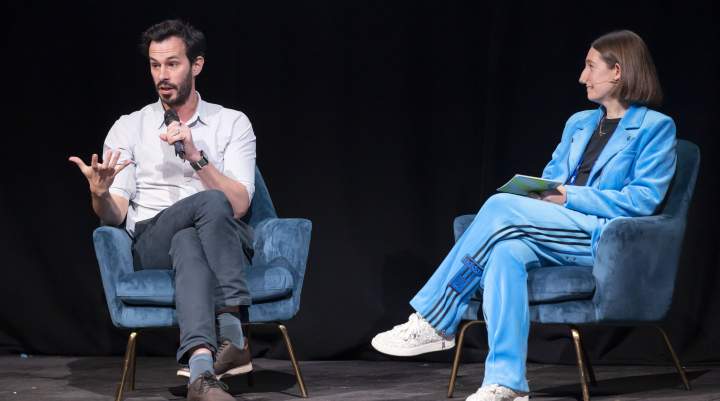 Two speakers sat on stage presenting